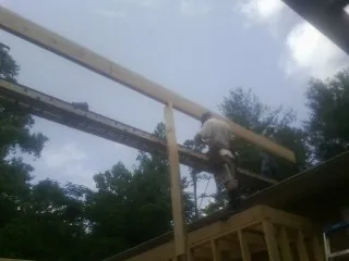 Carpenter setting a ridge beam over a new addition frame — Ice Dam Removal by Roofing Brothers in Gracey