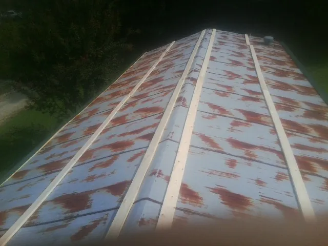 Rusted metal roof panels with new wood purlins before replacement — Storm Damage Roof Repair in Gracey by Roofing Brothers