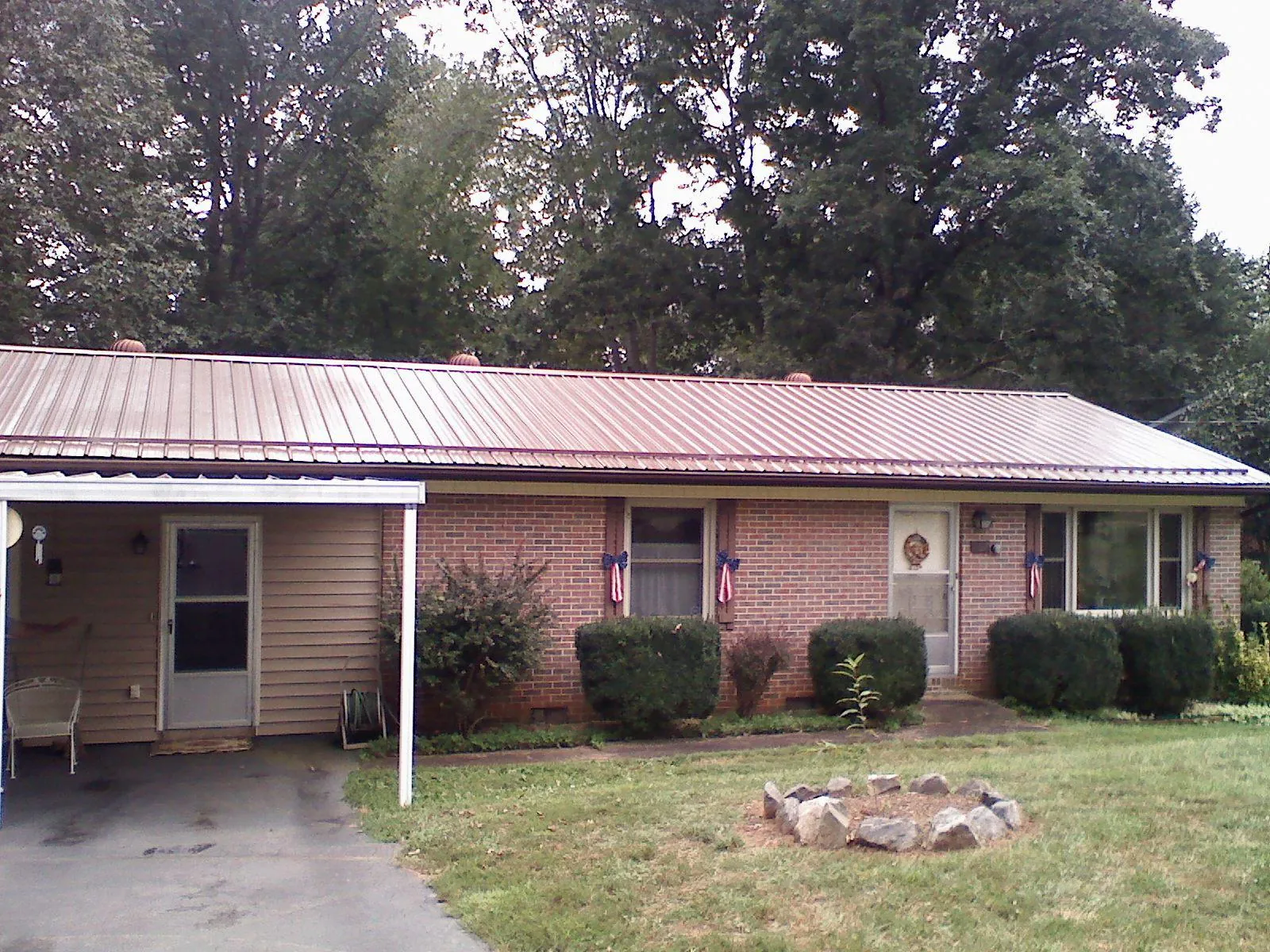 Bronze metal roof and carport on a brick ranch home — Roof Repair work by our crew in Gracey