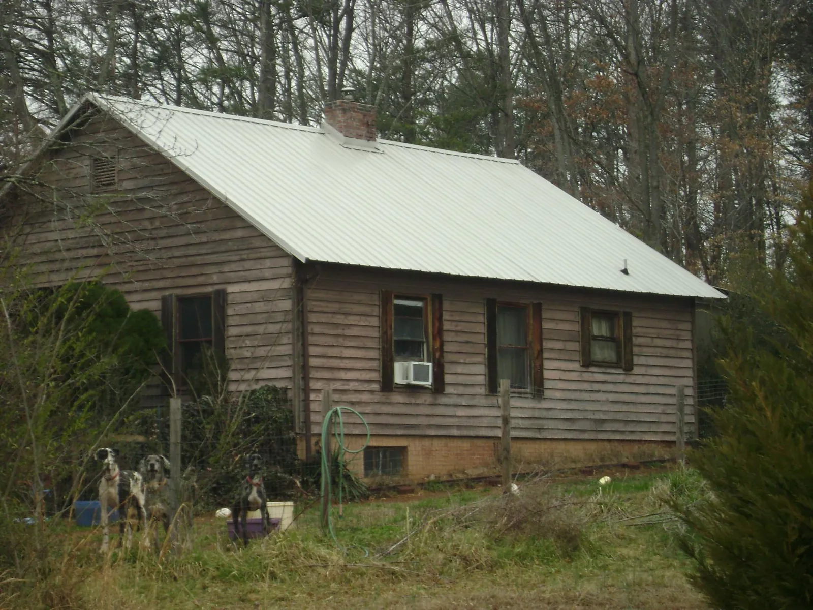 White metal roof on an old wood sided farmhouse, from a Metal Roof Installation job in Gracey